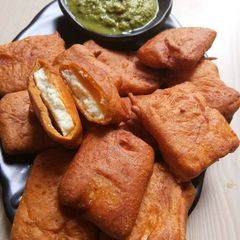 A picture of Paneer pakoda with green chutney.