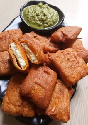 A picture of Paneer pakoda with green chutney.