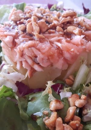 Una foto de Timbal de patata y salmón con vinagreta y crujiente de cacahuetes
