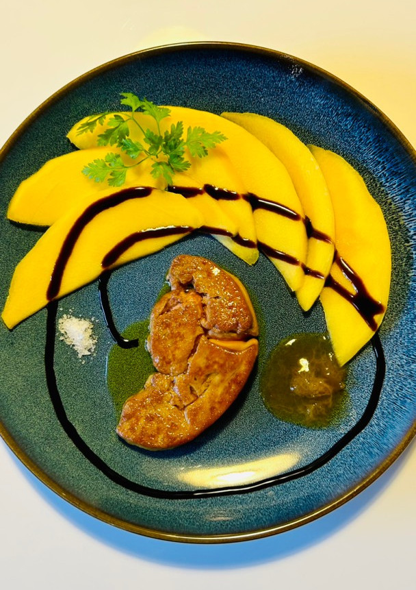 Una foto de Foie gras crudo a la plancha con mango y reducción de vinagre balsámico