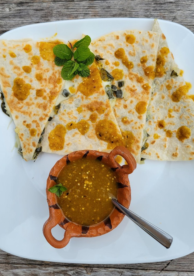 Una foto de Quesadillas con nopales, queso y salsa de tomatillo milpero
