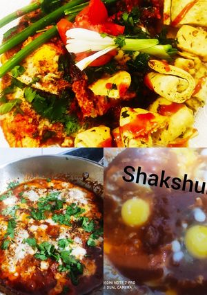 A picture of Shakshuka with warm garlic bread (poached eggs in spicy sauces).