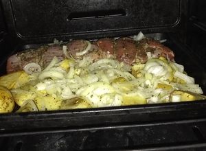 Una foto de Peceto al horno con papas y cebollas