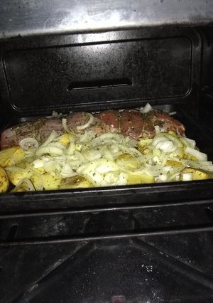 Una foto de Peceto al horno con papas y cebollas