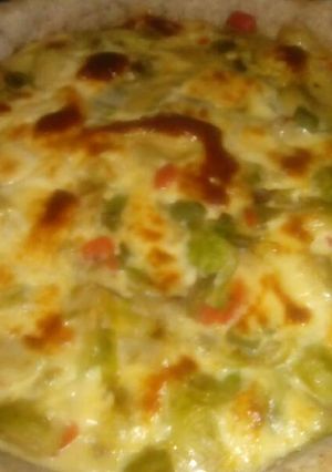 Una foto de Tarta de repollitos de bruselas y vegetales con masa de harina integral.