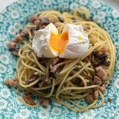 A picture of Mushroom pancetta pasta poached egg on top.