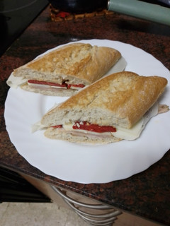Una foto de Bocadillo de pata asada con pimiento del piquillo, queso curado y huevo duro