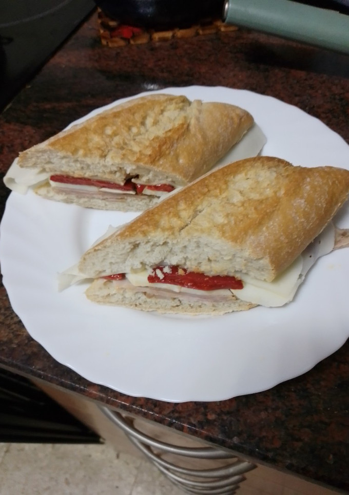 Una foto de Bocadillo de pata asada con pimiento del piquillo, queso curado y huevo duro