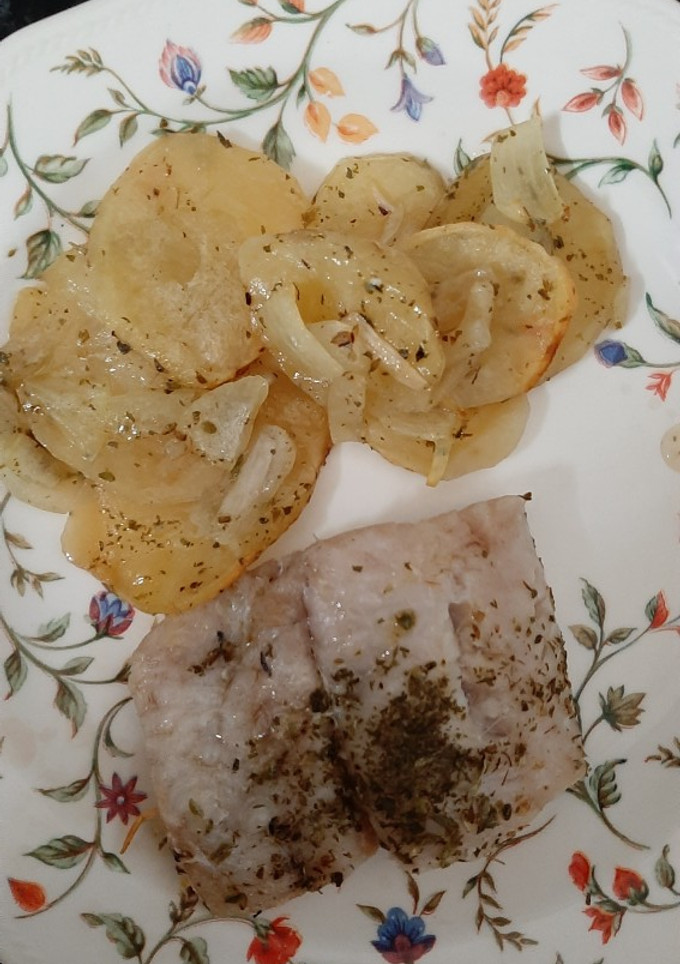 Una foto de Merluza al horno sobre cama de panaderas y cebolla