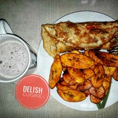 A picture of Fried plantain and eggs with a cup of hot tea.