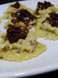 Una foto de Canapés crujientes de queso parmesano con hummus y chutney de cebolla caramelizada