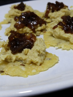 Una foto de Canapés crujientes de queso parmesano con hummus y chutney de cebolla caramelizada