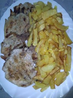 Una foto de Patatas fritas con chuletas de cerdo al ajillo