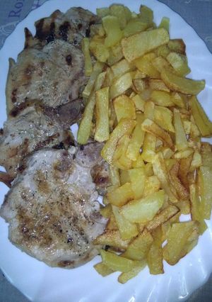 Una foto de Patatas fritas con chuletas de cerdo al ajillo