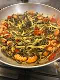 Tagliatelle bianche nere con pomodorini datterino e code di scampi