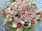Una foto de ensalada de tomate cherry y albahaca