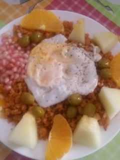 Una foto de Migas con chorizos, melón, naranja, granadas, huevo y aceitunas