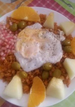 Una foto de Migas con chorizos, melón, naranja, granadas, huevo y aceitunas