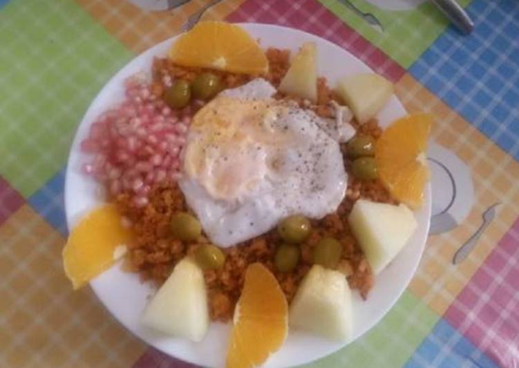 Migas con chorizos, melón, naranja, granadas, huevo y aceitunas