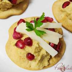 Una foto de Canapés de hummus y queso tierno de oveja con granada