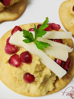 Una foto de Canapés de hummus y queso tierno de oveja con granada