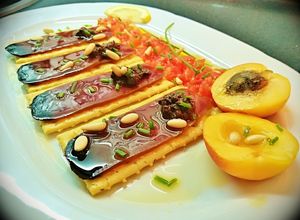 Foto principal de Pincho de mojama con olivada, tomate, albaricoque y piñones