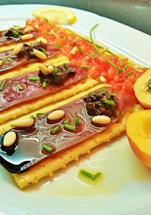 Foto principal de Pincho de mojama con olivada, tomate, albaricoque y piñones