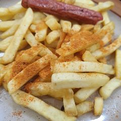 A picture of French fries with sausage.