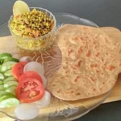 A picture of Sprouted moong sabzi with Kadak Paratha and Salad.