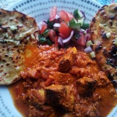 A picture of Chicken Tikka Masala with Garlic Flatbreads and Kachumber.