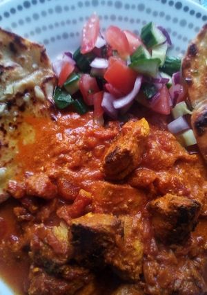 A picture of Chicken Tikka Masala with Garlic Flatbreads and Kachumber.