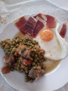 Una foto de Combinado de guisantes con ternera, huevo frito y jamón serrano