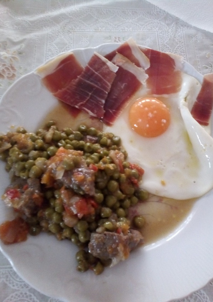 Una foto de Combinado de guisantes con ternera, huevo frito y jamón serrano