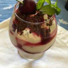 Foto di Coppa di mousse al cioccolato bianco con succo di amarene e scaglie di cioccolato