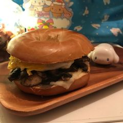 A picture of Fried Egg 🍳🥪Mushrooms 🍄 Melting Cheese Bagel🍩🍔.