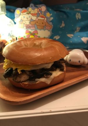 A picture of Fried Egg 🍳🥪Mushrooms 🍄 Melting Cheese Bagel🍩🍔.