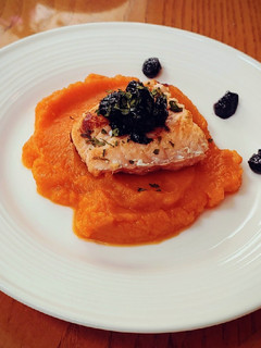 A picture of Sauteed salmon filet on sweet potato puree with bluberry compote.
