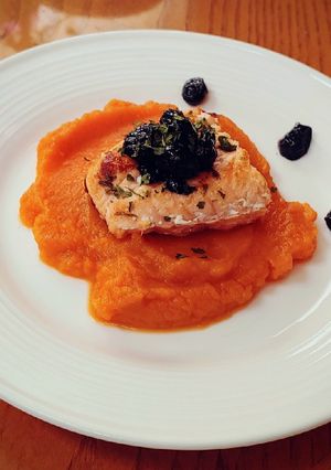 A picture of Sauteed salmon filet on sweet potato puree with bluberry compote.
