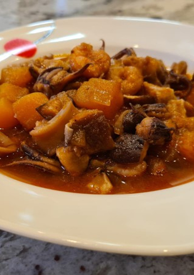 Una foto de Chipirones guisados con calabaza, setas y gambas