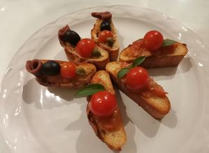 Una foto de Bruschetta de pasta de aceitunas y crostini de tomate