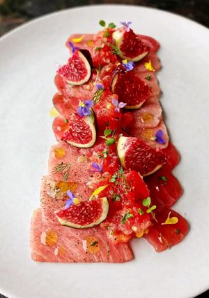 Foto di Tataki di Tonno con Carpaccio di Pomodoro, Fichi e Fiori di Campo