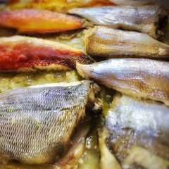 Una foto de Pescados de la Ria de A Coruña al horno sobre cama de patatas