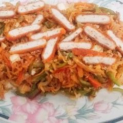 A picture of Leftover roty chowmeing with chicken nugget strips.