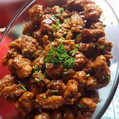 A picture of Chicken Nuggets in sauce.