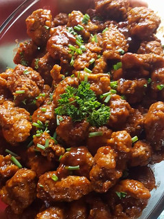 A picture of Chicken Nuggets in sauce.