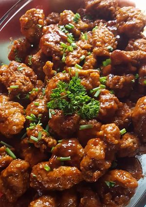 A picture of Chicken Nuggets in sauce.