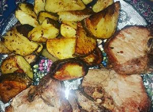 Una foto de Chuletas de cerdo o costeletas con papas al horno