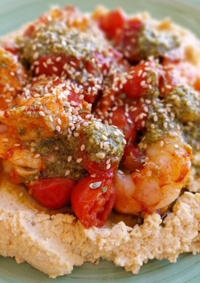 Una foto de Hummus con gambas, cherrys y un toque de pesto