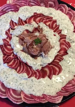 Une photo de Carpaccio de betteraves schiogga et jambon cru sauce fromage blanc et citron aux herbes