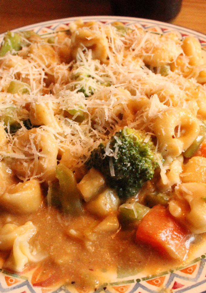 Una foto de Tortelinis con salsa amarilla-marroncita